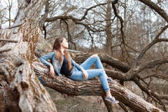Young pretty woman in denim clothes sitting and resting on a big Royalty Free Stock Photography Young pretty woman in denim clothes sitting and resting on a big Royalty Free Stock Photography