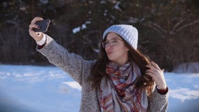 Young pretty woman posing for the camera at sunny winter day. stock video Young pretty woman posing for the camera at sunny winter day. stock video