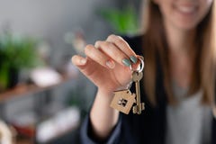 Young pretty woman smiles. House key in womans hands. . Modern light lobby interior. Real estate, hypothec, moving home stock photos Young pretty woman smiles. House key in womans hands. . Modern light lobby interior. Real estate, hypothec, moving home stock photos