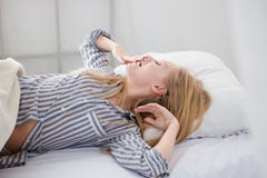 Young pretty woman yawning and stretching herself lying in bed royalty free stock photos Young pretty woman yawning and stretching herself lying in bed royalty free stock photos