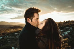 Young Romantic Couple Kissing At A Sunset In The Countryside. Concept Of Relationship With Love And Passion Stock Photo Young Romantic Couple Kissing At A Sunset In The Countryside. Concept Of Relationship With Love And Passion Stock Photo