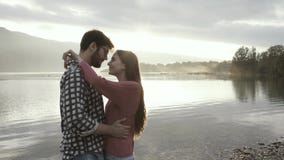 Young romantic couple kissing at sunset