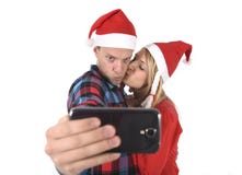 Young romantic couple in love taking selfie mobile phone photo at Christmas Royalty Free Stock Images Young romantic couple in love taking selfie mobile phone photo at Christmas Royalty Free Stock Images