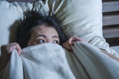 Young Scared And Stressed Asian Chinese Woman Lying In Bed Suffering Nightmare In Fear And Panic Grasping Blanket Covering Her Hor Stock Image Young Scared And Stressed Asian Chinese Woman Lying In Bed Suffering Nightmare In Fear And Panic Grasping Blanket Covering Her Hor Stock Image