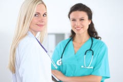 Young smiling female surgeon doctor standing at hospital. Medicine and health care concept royalty free stock photography Young smiling female surgeon doctor standing at hospital. Medicine and health care concept royalty free stock photography