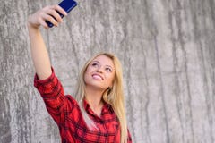 Young Smiling Girl With Beautiful Face Taking Self-portrait On Her Smartphone. She Has Blonde Hair, Beaming Smile. She Is Wearing Royalty Free Stock Photos