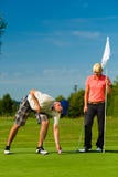 Young sportive couple playing golf on a course stock photos Young sportive couple playing golf on a course stock photos