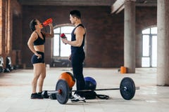 Young strong man and woman drinking water during the training stock image Young strong man and woman drinking water during the training stock image