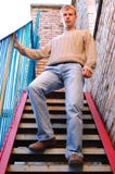 Young Stylish Man Stay On Stairs Near Brick Wall. Royalty Free Stock Image