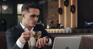 Young successful businessman with smartwatch sitting in cafe. Freelancer view the messages, activate the applications stock video Young successful businessman with smartwatch sitting in cafe. Freelancer view the messages, activate the applications stock video