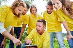Young team with tablet computer discusses strategy stock image Young team with tablet computer discusses strategy stock image