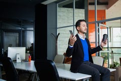 Young tired businessman meditating on table with mobile phone and coffee stock photo Young tired businessman meditating on table with mobile phone and coffee stock photo