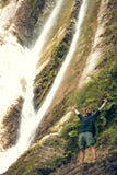 Young tourist camping with backpack near a waterfall in forest. royalty free stock image Young tourist camping with backpack near a waterfall in forest. royalty free stock image