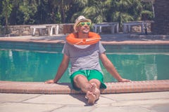 Young tourist enjoying the summer day at the poolside stock photo Young tourist enjoying the summer day at the poolside stock photo