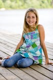 Young Tween Girl Sitting On A Pier Royalty Free Stock Image