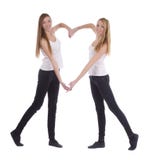 Young twins sisters making heart shape with arms Stock Images Young twins sisters making heart shape with arms Stock Images
