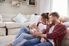 Young white family with toddler together in sitting room stock photo Young white family with toddler together in sitting room stock photo