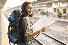Young woman backpacker smiling and holding map for planning rout stock image Young woman backpacker smiling and holding map for planning rout stock image