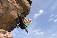 Young woman climbig a rock