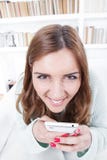 young woman with crazy face expression is trying to spite insidiously with a mobile phone stock photo young woman with crazy face expression is trying to spite insidiously with a mobile phone stock photo