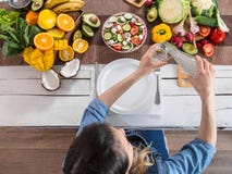 A young woman at the dinner table pours water stock photography A young woman at the dinner table pours water stock photography