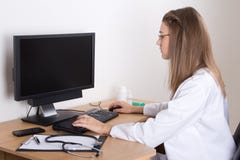 Young woman doctor using computer with empty screen Stock Photos Young woman doctor using computer with empty screen Stock Photos