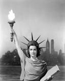 Young woman dressed as the Statue Of Liberty with skyscrapers in the background