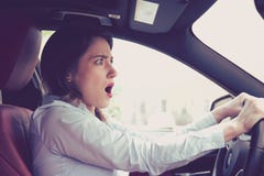 Young woman driving a car shocked about to have traffic accident
