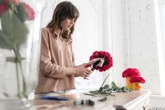 Young Woman Florist Arranging Plants In Flower Shop. People, Business, Sale And Floristry Concept. Bouquet Of Red Roses Royalty Free Stock Images