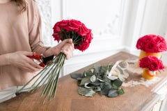 Young Woman Florist Arranging Plants In Flower Shop. People, Business, Sale And Floristry Concept. Bouquet Of Red Roses Stock Image