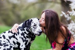 Young Woman Gives Her Dalmatian Dog A Kiss Stock Photo