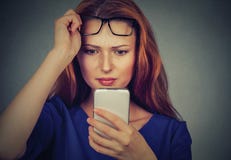 Young woman with glasses having trouble seeing cell phone has vision problems Royalty Free Stock Photos Young woman with glasses having trouble seeing cell phone has vision problems Royalty Free Stock Photos