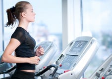 Young woman at the gym. Run on a machine