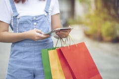 Young woman hand holding tablet smart device and shopping bags with standing at the car parking lot royalty free stock photos Young woman hand holding tablet smart device and shopping bags with standing at the car parking lot royalty free stock photos