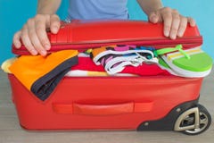Young Woman Hands Packing Suitcase. Women& X27;s Clothes And Accessories In Red Suitcase Things Prepared For Travel Royalty Free Stock Photo