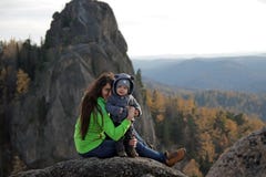 A young woman with her little son on top of a mountain. stock photo A young woman with her little son on top of a mountain. stock photo