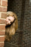 Young Woman Hiding Around Corner Royalty Free Stock Photography