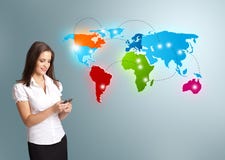 Young woman holding a phone and presenting colorful world map stock photo Young woman holding a phone and presenting colorful world map stock photo