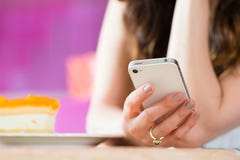 Young woman in ice cream parlor with phone texting