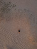 Young Woman In A Black Dress Lying On The Back On The Sand. Top View From The Drone Royalty Free Stock Photography Young Woman In A Black Dress Lying On The Back On The Sand. Top View From The Drone Royalty Free Stock Photography