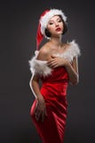 Young Woman In A Red Skirt And Santa Claus Hat On A Light Background Celebrates Christmas Stock Images