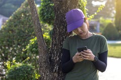 Young woman leaning against tree with staring mobile. stock photography Young woman leaning against tree with staring mobile. stock photography