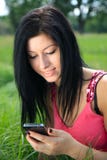 Young Woman Looking At Phone And Smiling Royalty Free Stock Photography