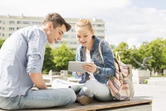Young woman with male friend using digital tablet at college campus royalty free stock images Young woman with male friend using digital tablet at college campus royalty free stock images