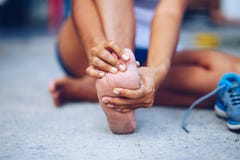 Young woman massaging her painful foot from exercising stock photos Young woman massaging her painful foot from exercising stock photos