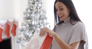 Young woman opening a Christmas gift bag
