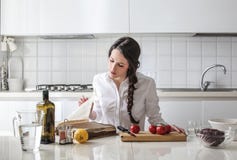 Young woman reading a cook book Stock Images Young woman reading a cook book Stock Images