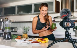 Young woman recording content for her video blog in kitchen. Stock Photos Young woman recording content for her video blog in kitchen. Stock Photos