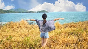 Young woman relaxing with meadow, sea, mountain, blue sky and cloud at Koh Sichang.
