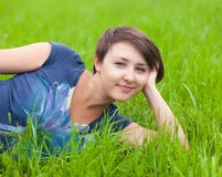 Young Woman Relaxing On The Green Grass Royalty Free Stock Photo